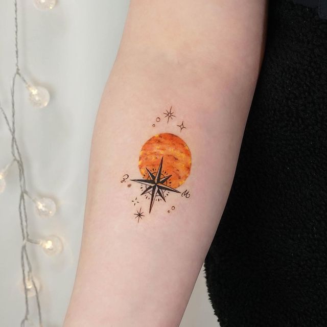Shining orange Venus and a compass arm tattoo
