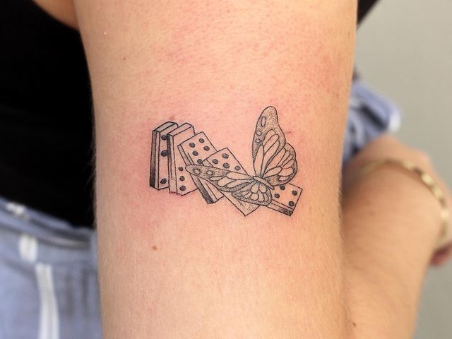 butterfly on dominos arm tattoo