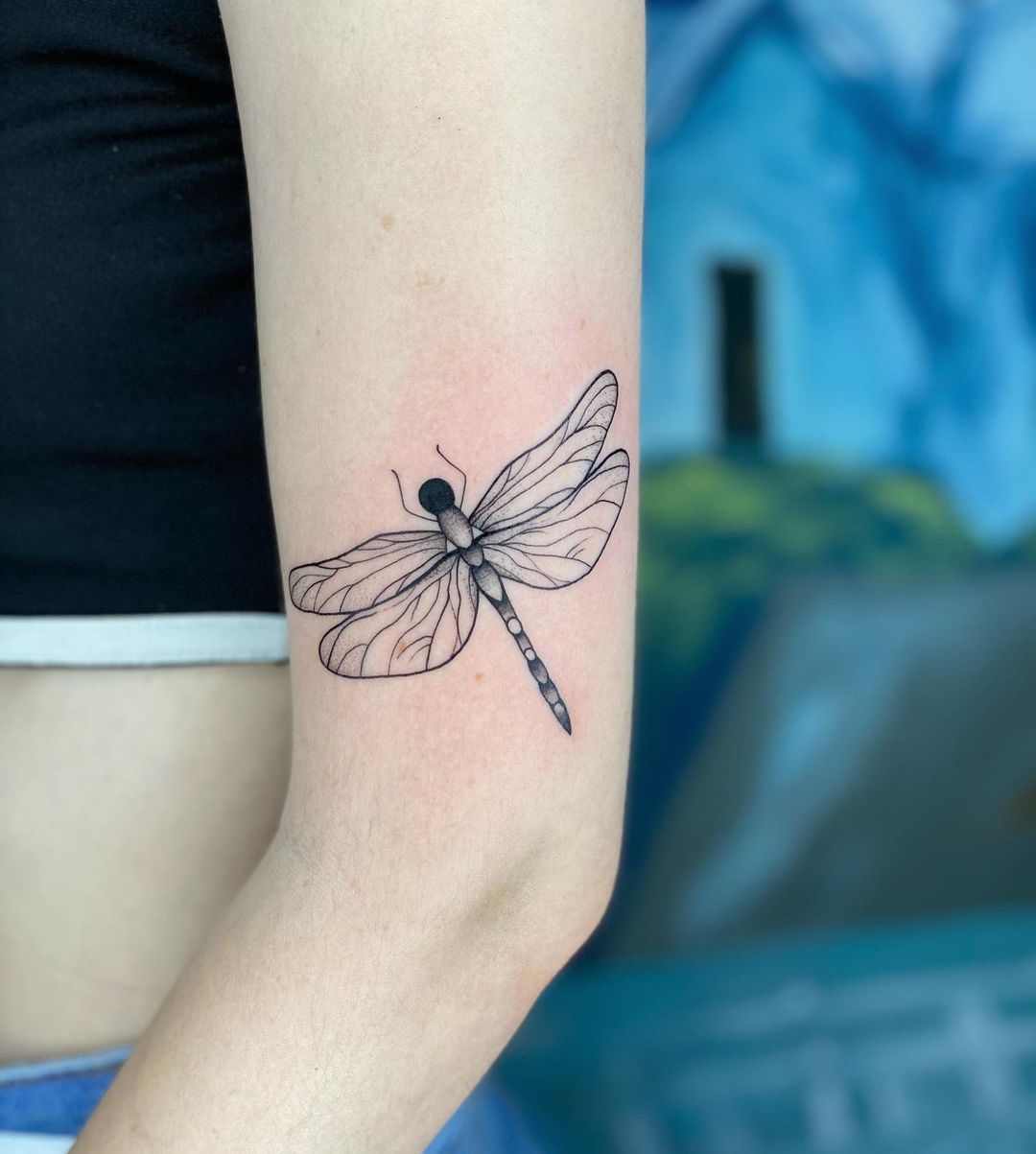 Dragonfly arm tattoo