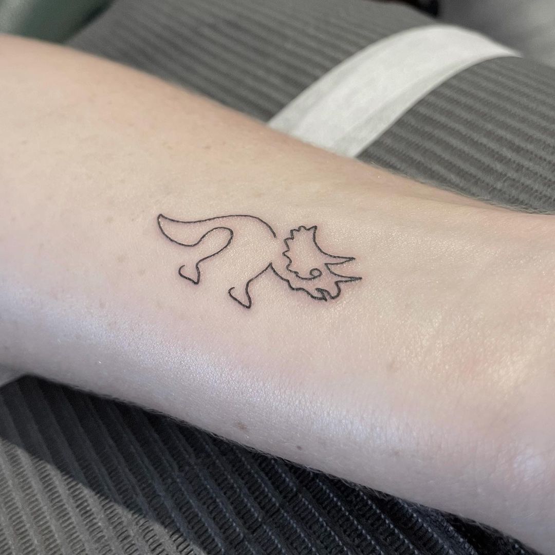 Minimalist triceratops arm tattoo