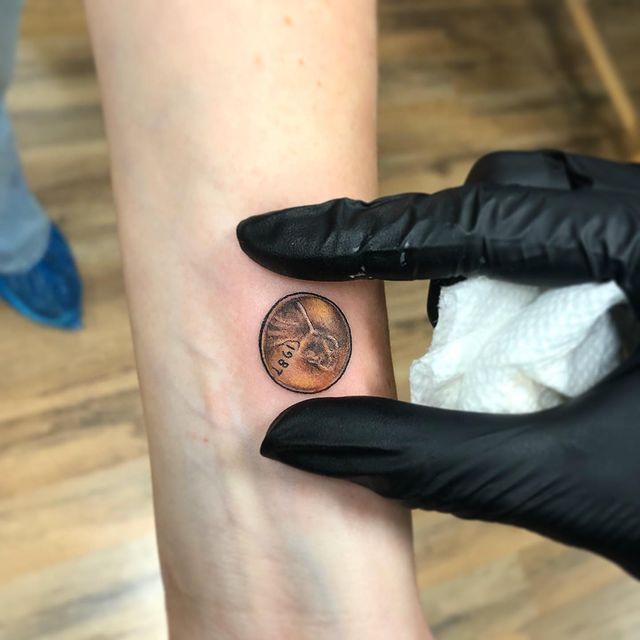 penny arm tattoo
