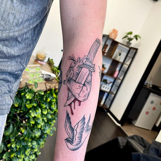 Stabbed heart arm tattoo 