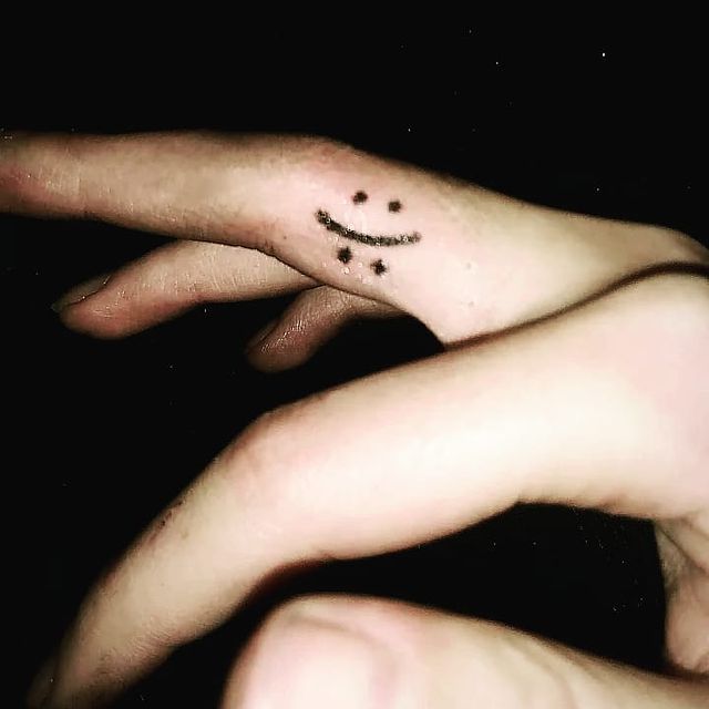 Happy sad face finger tattoo 