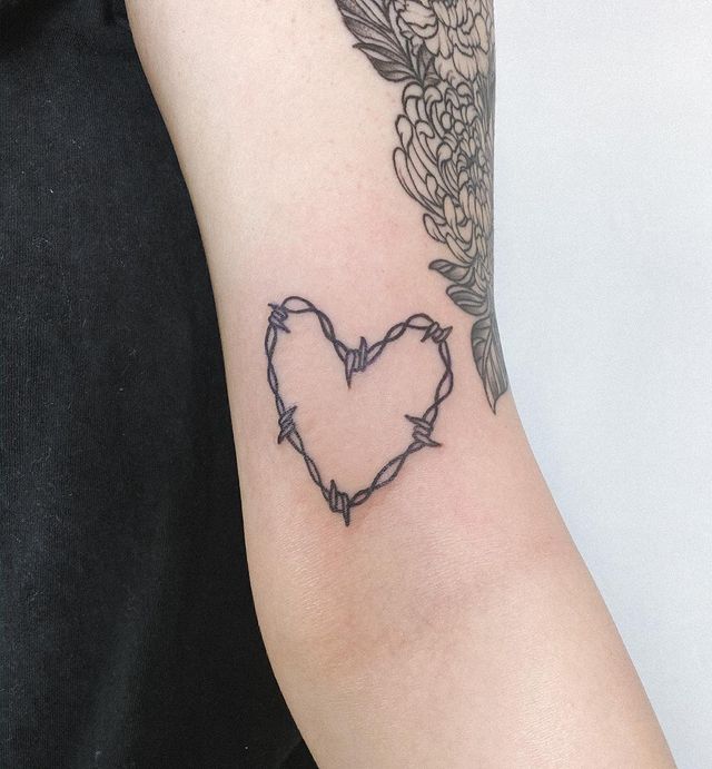 Barbed wire heart arm tattoo