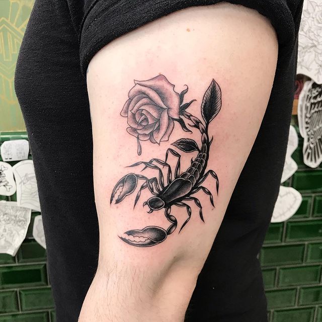 A scorpion with a rose tail tattoo