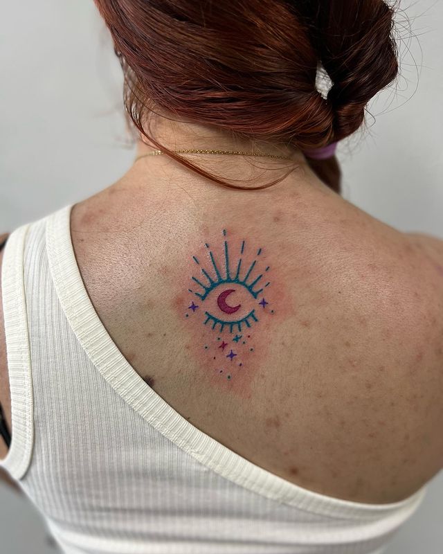 colorful eye moon tattoo in the back